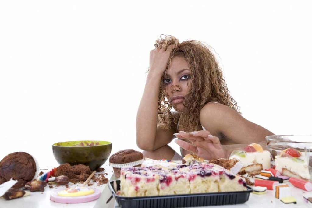 A Woman Sitting In Front Of Sugary Foods Photo Nutrition Advance